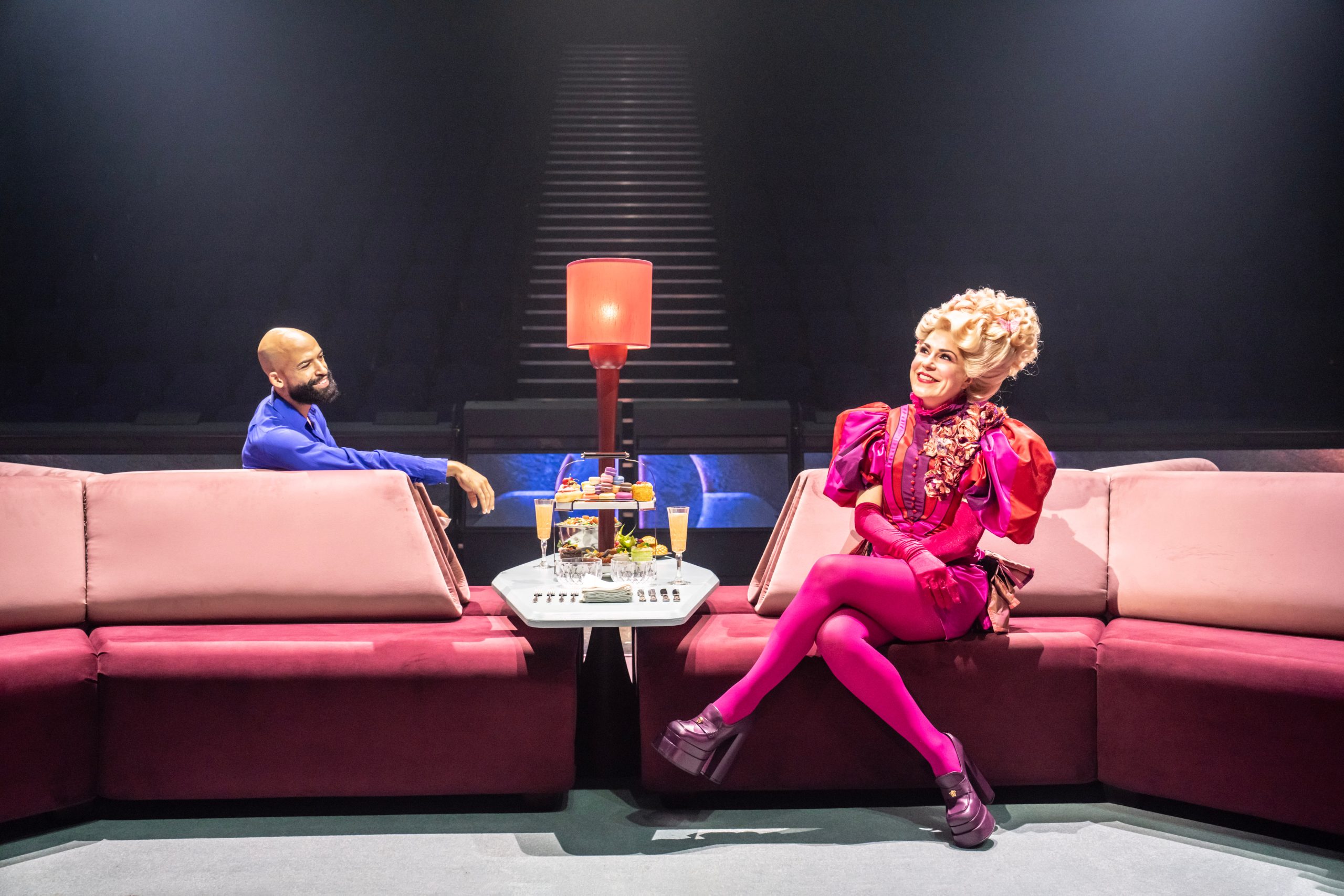 Cinna and Effie Trinket on the tribute train in The Hunger Games: On Stage